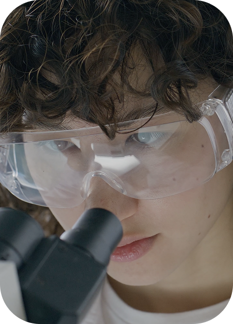 Researcher looking into microscope
